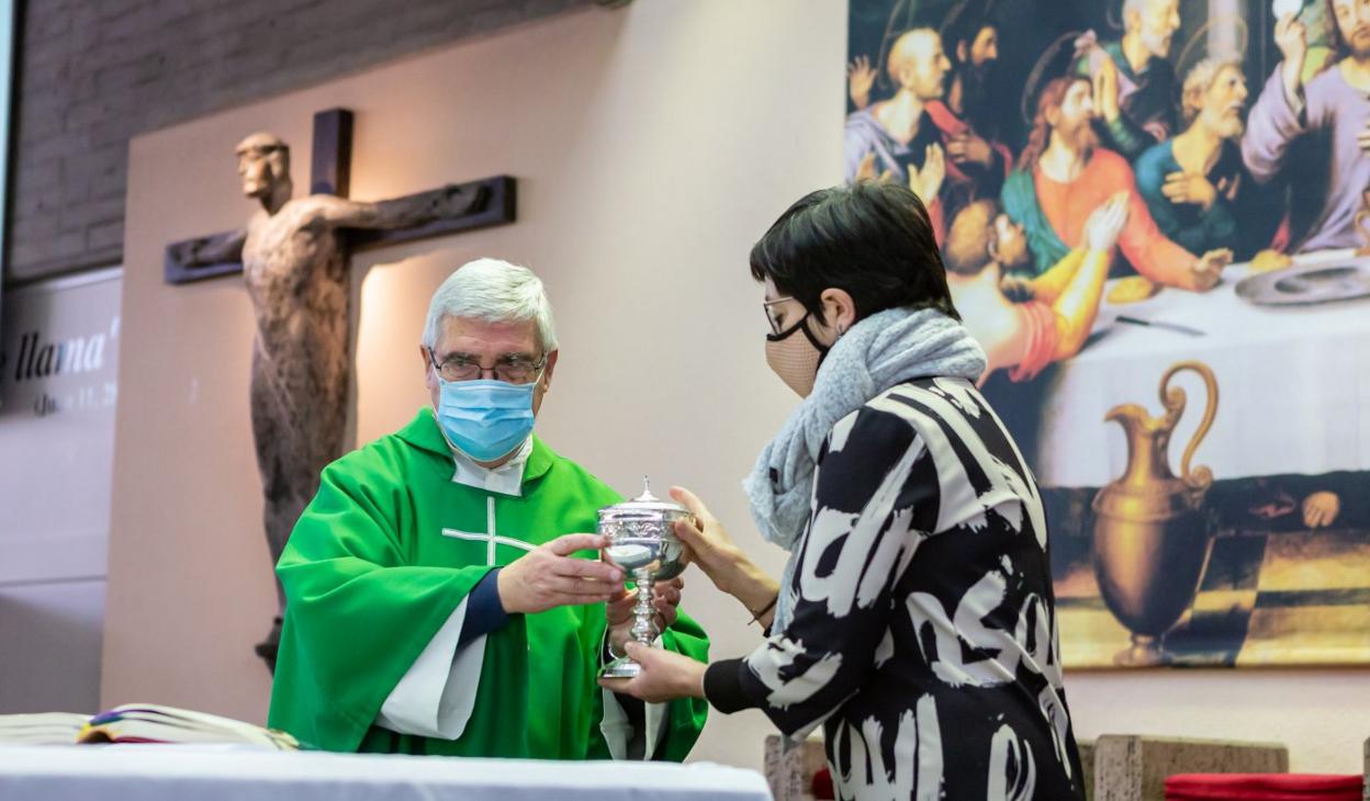 Una mujer ayuda al sacerdote en la iglesia San Pablo. 