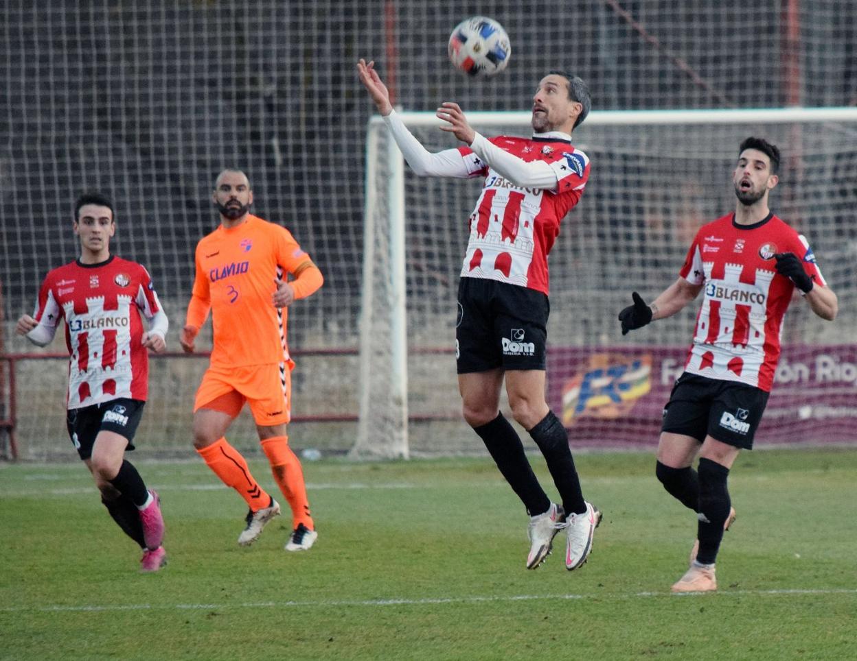 El blanquirrojo Caneda salta para controlar un balón. 