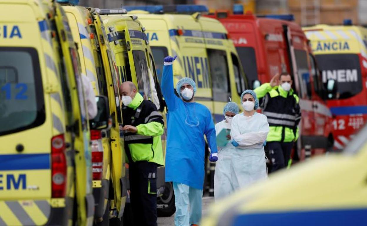 Un trabajador de la salud hace un gesto junto a las ambulancias que transportan pacientes fuera del Hospital Santa María, en Lisboa (Portugal) 