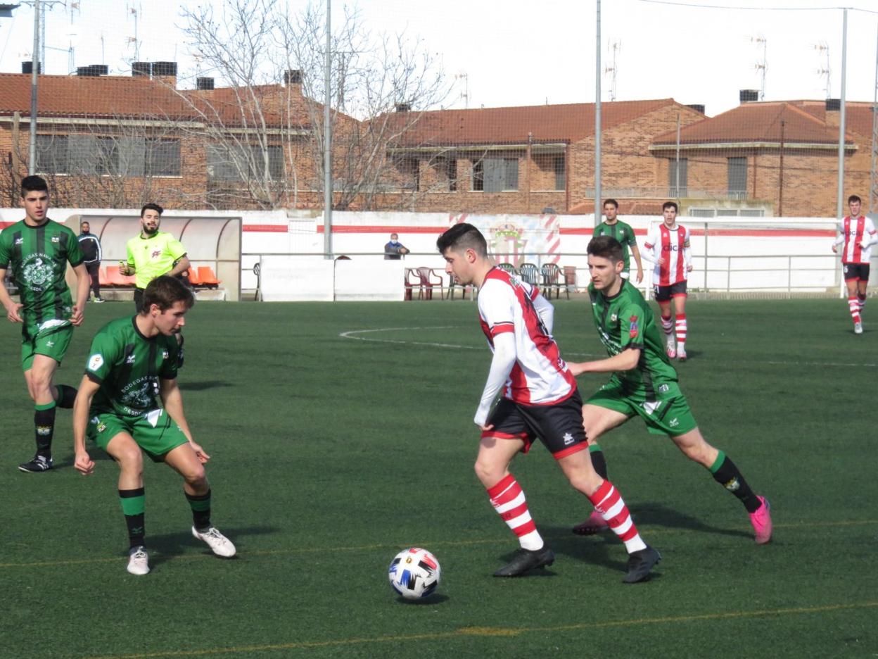 El rinconero Iñaki intenta marcharse ante la férrea defensa visitante. 