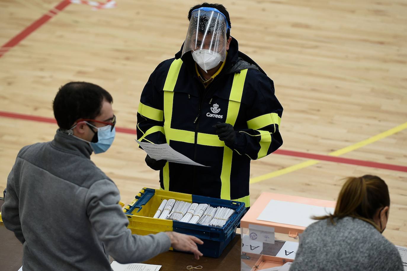 Un empleado de Correos lleva a una mesa electoral los votos emitidos por correo.