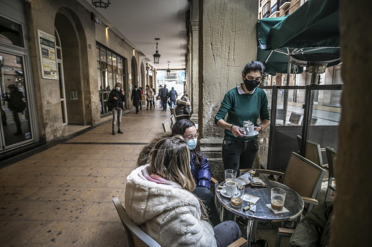 Dos clientas mantienen la mascarilla mientras disfrutan de un café en una terraza de Portales. 