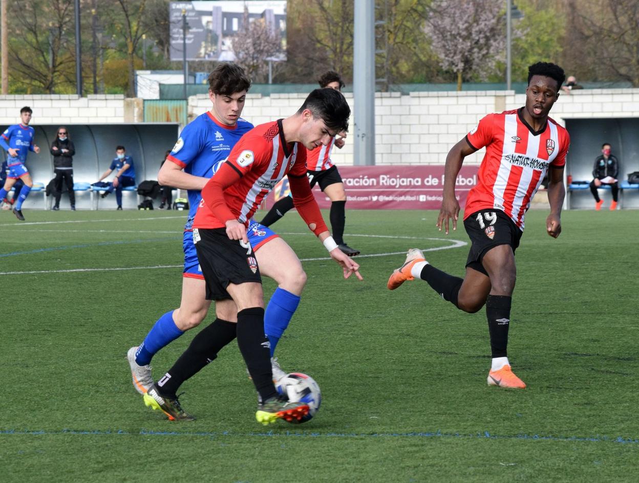 Antonio, de la UD Logroñés B, se hace con el cuero ante la presión del jugador calagurritano Pablo. 