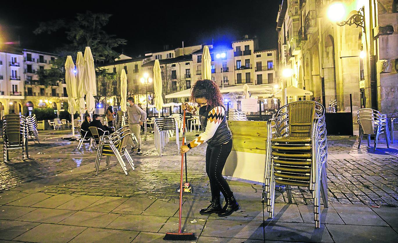 Limpieza tras recoger la terraza en la plaza del Mercado en torno a las 22.45 horas del viernes. 