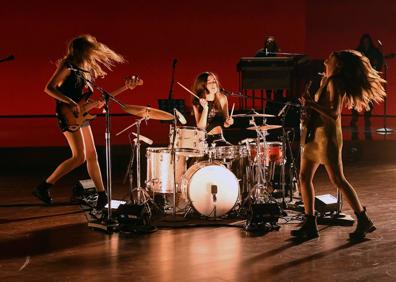 Imagen secundaria 1 - Las Haim, durante su potente actuación y Taylor Swift, recibiendo el premio al mejor álbum del año.