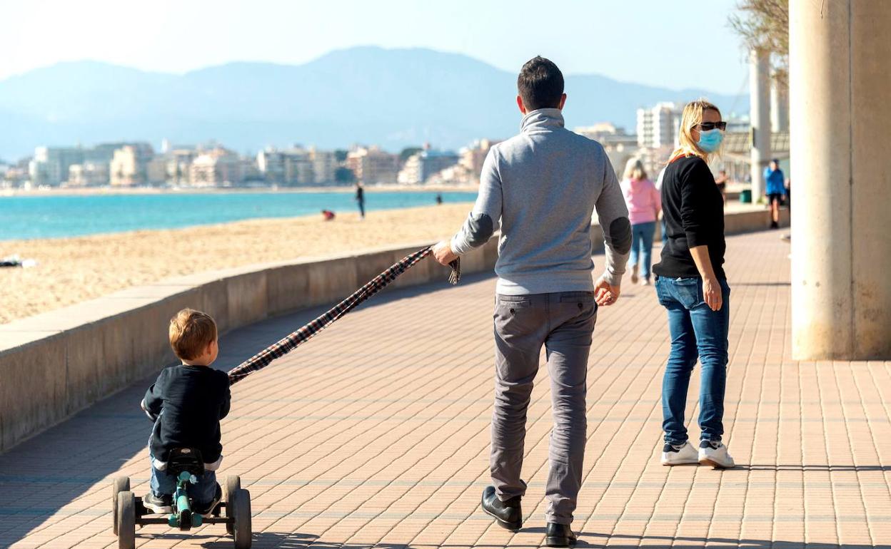 Una familia pasea por el paseo marítimo.