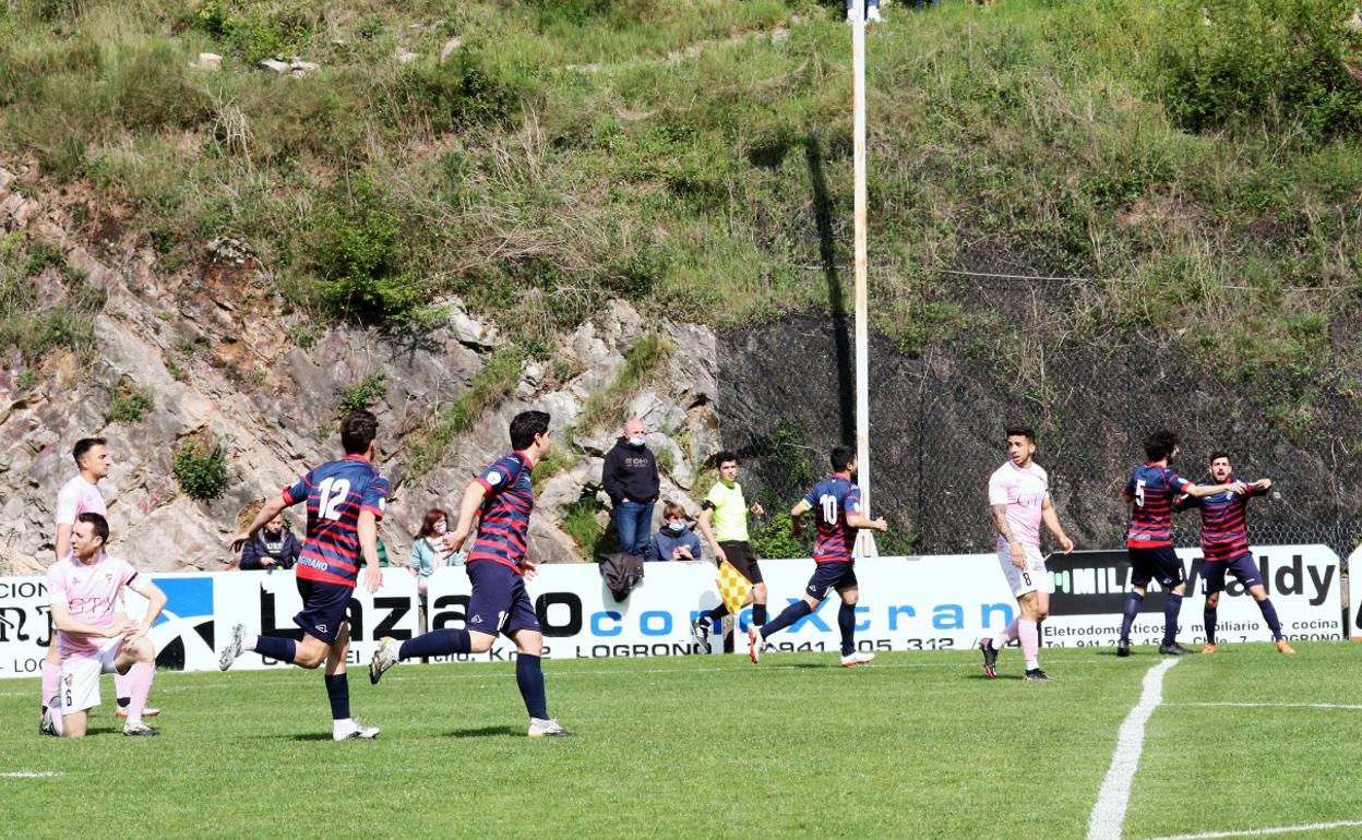 Los jugadores locales celebran el tanto del primer empate mientras que los del Racing Rioja sufren el tanto. 