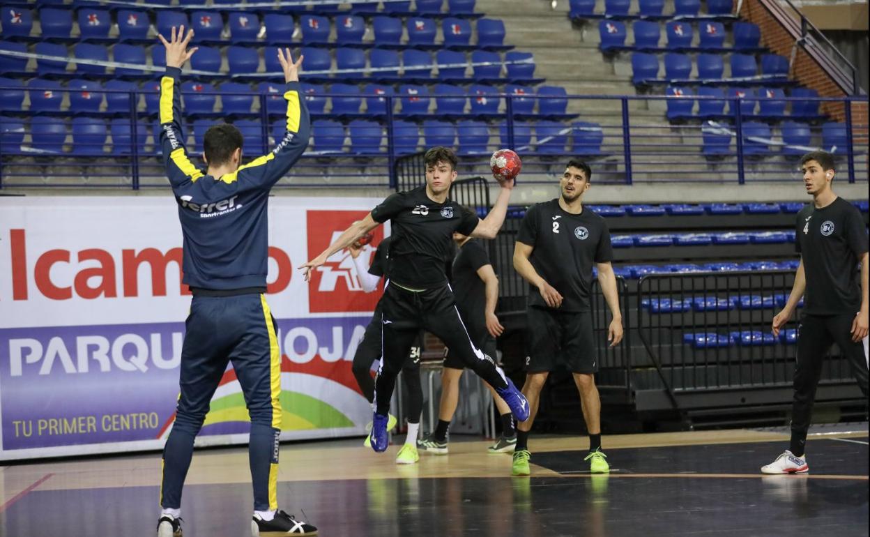 Edu Ortiz lanza desde el extremo en un entrenamiento ante la mirada de Mario Dorado y Miguel Sánchez-Migallón. 