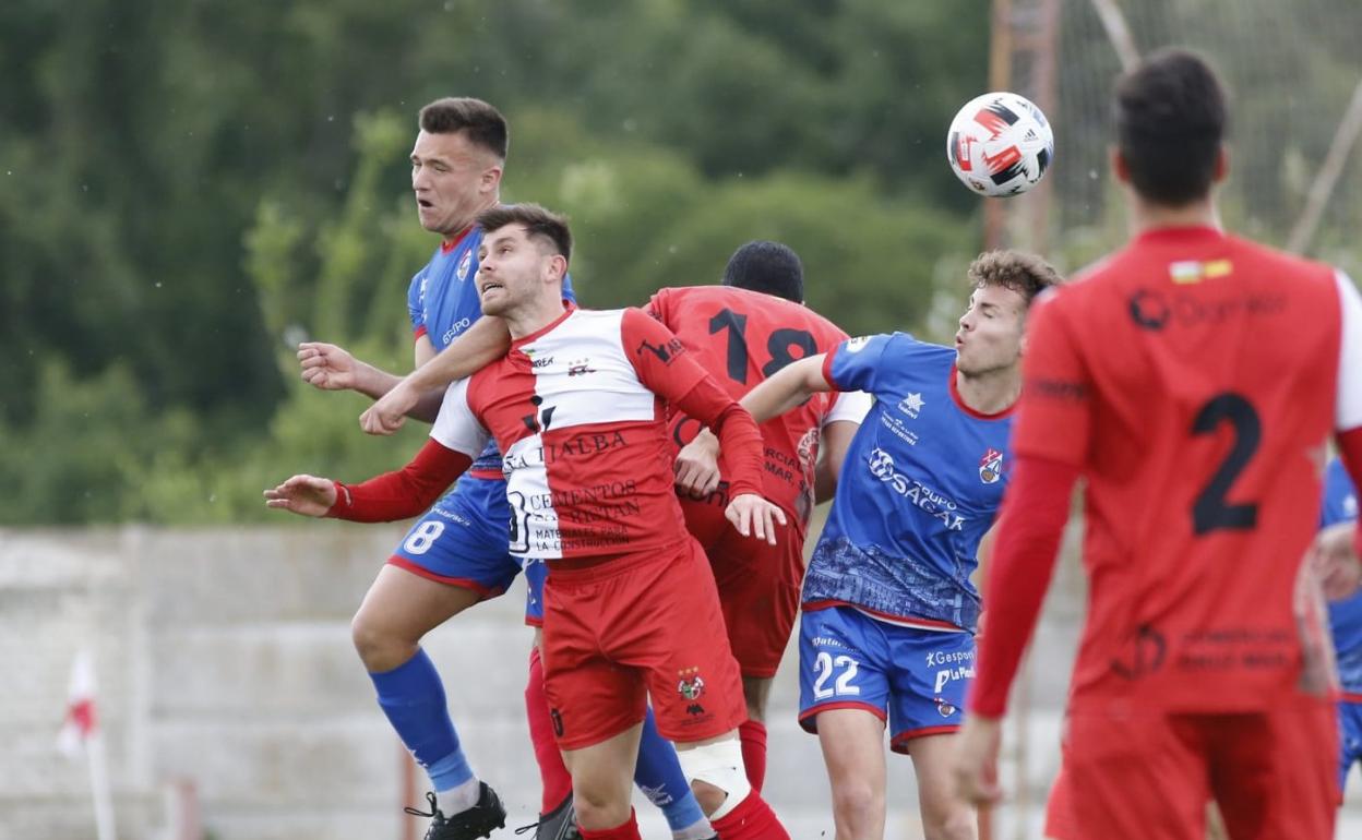 Jugadores de ambos equipos luchan por un balón aéreo en los primeros compases del choque. 