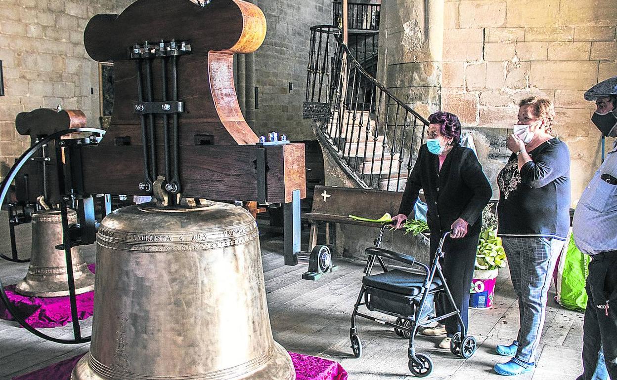 Varios vecinos de Graón observan las campanas durante su exposición en la iglesia parroquial. 