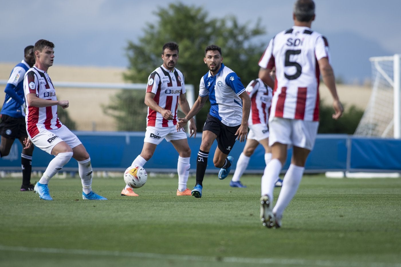 Xiker y Emilio juegan el balón ante un futbolista rival. 