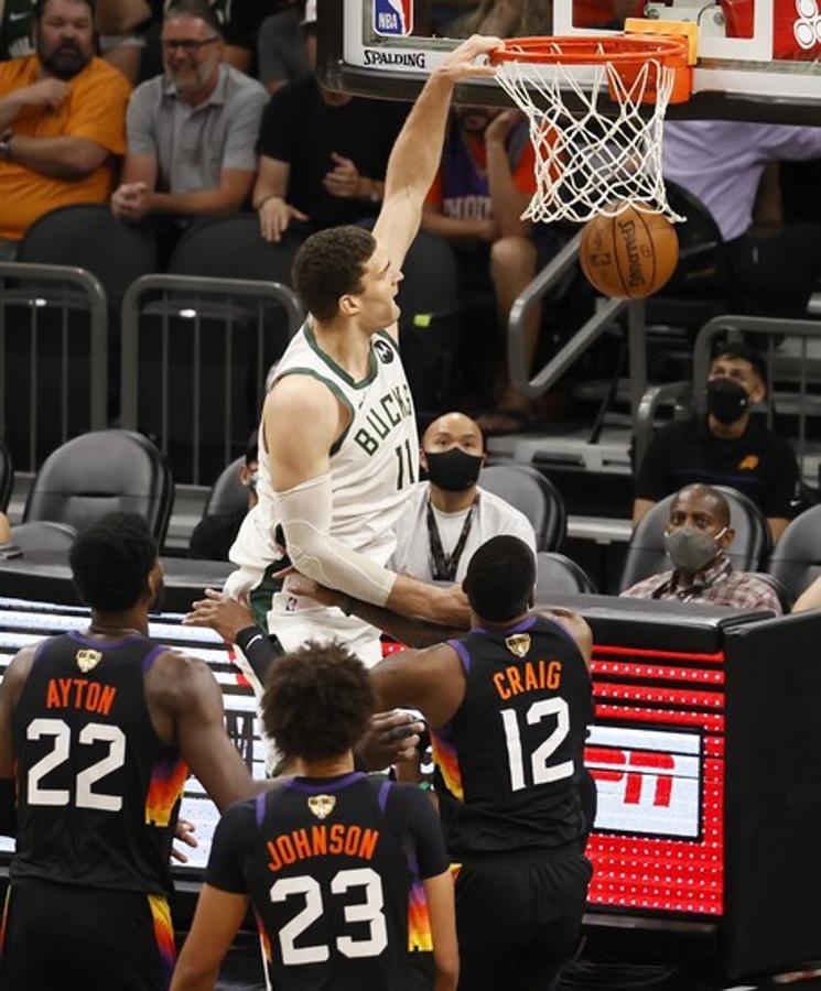 El jugador de los Bucks, Brook Lopez, hace un mate ante tres atónitos integrantes de los Suns. 