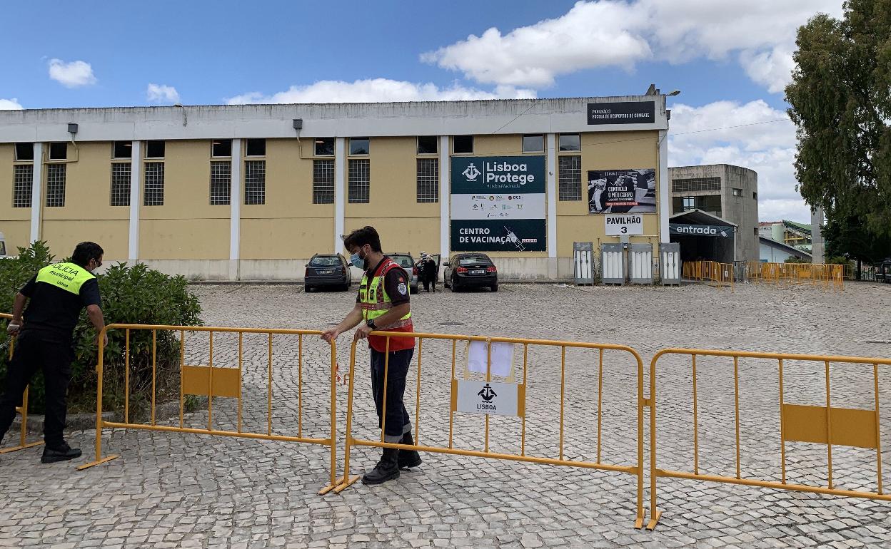 Agentes de la Policía Municipal portuguesa colocan vallas en el Estadio Universitario de Lisboa, reconvertido en centro de vacunación masiva. 