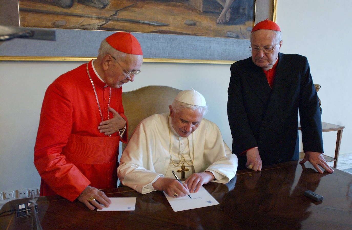 El Papa Benedicto XVI acompañado del italiano Agnelo Sodano (d) y el español Eduardo Martinez Somalo, firma un documento con su nuevo nombre durante su visita a las dependencias papales en el Vaticano