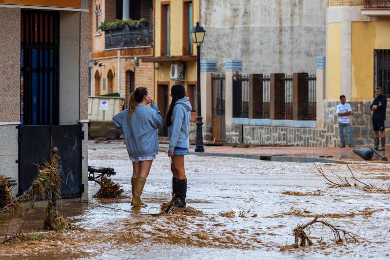 Dos personas observan una calle inundada en el municipio de Guadamur, Toledo