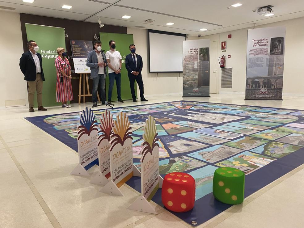 Organizadores de la exposición explican los detalles ante el juego de la Oca. 