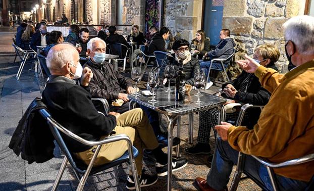 Varias personas sentadas en una terraza de un bar. 