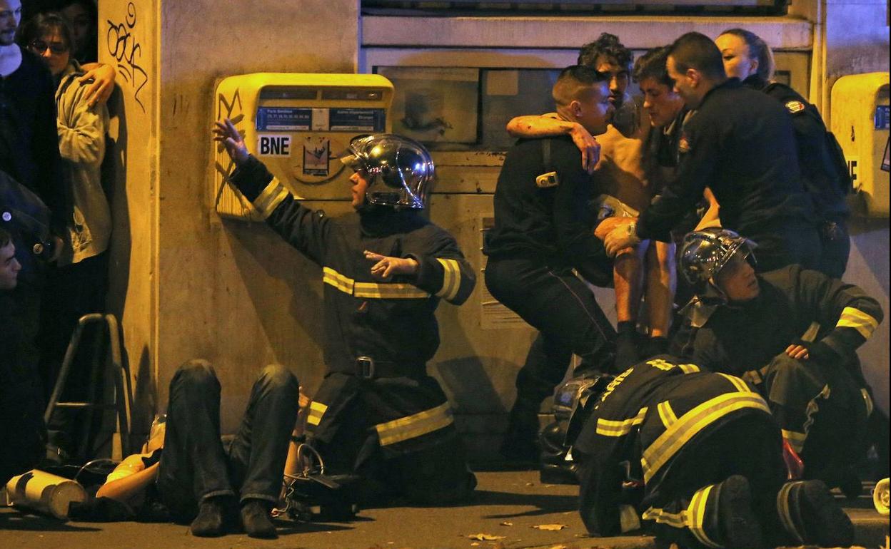 Los bomberos ofrecen los primeros auxilios a un grupo de víctimas de los ataques de la sala Bataclan.