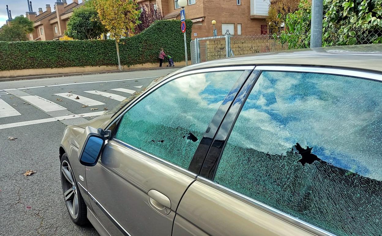 Un coche con desperfectos en la calle Rosalía de Castro de Lardero. 