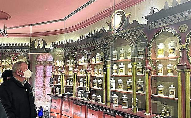 Un visitante observa los botes del boticario. 