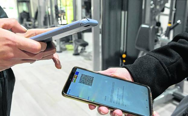 El gimnasio AltaFit 24 de Logroño revisa el pasaporte COVID de una clienta. 