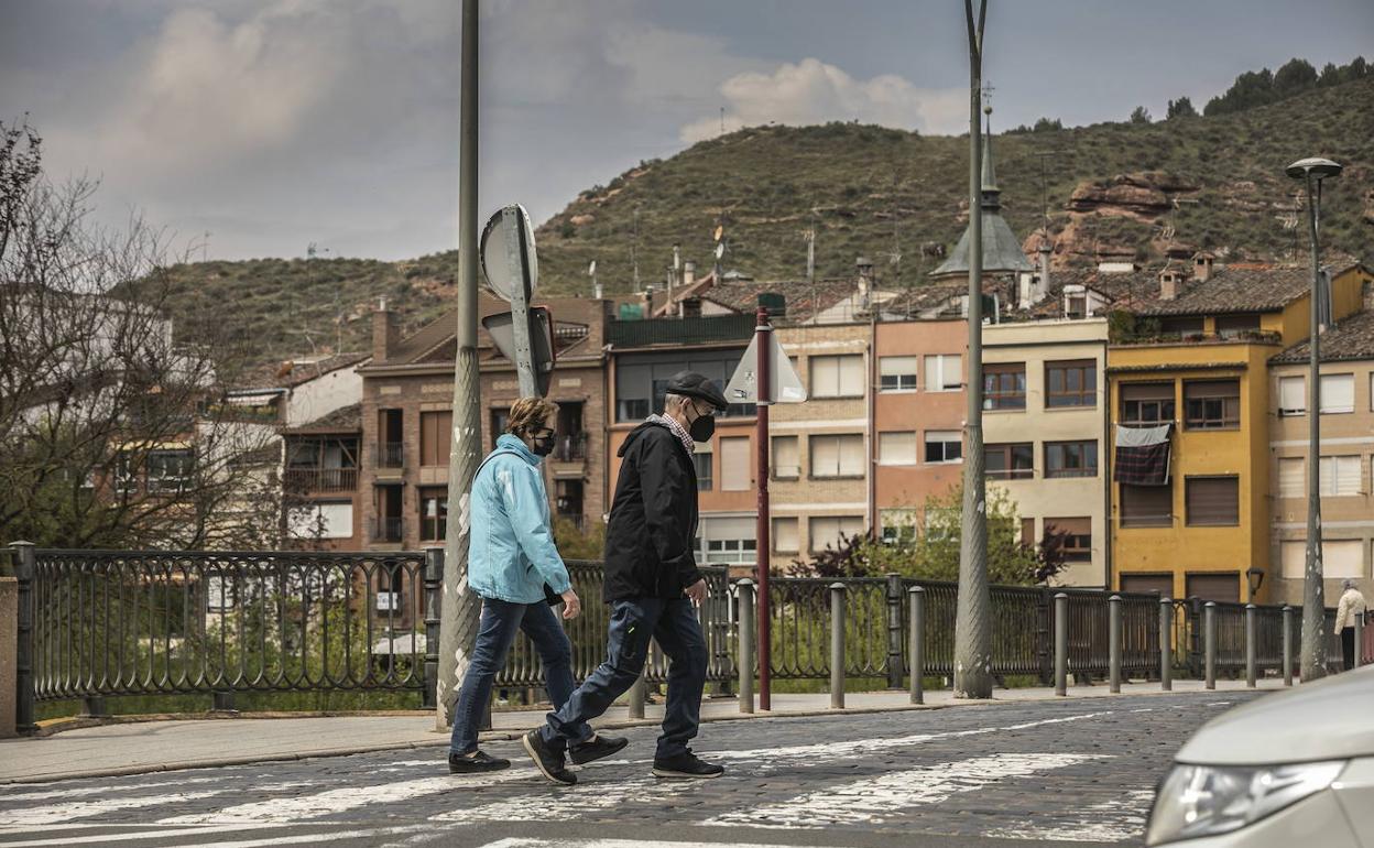 Dos personas cruzan un paso de peatones en Nájera. 