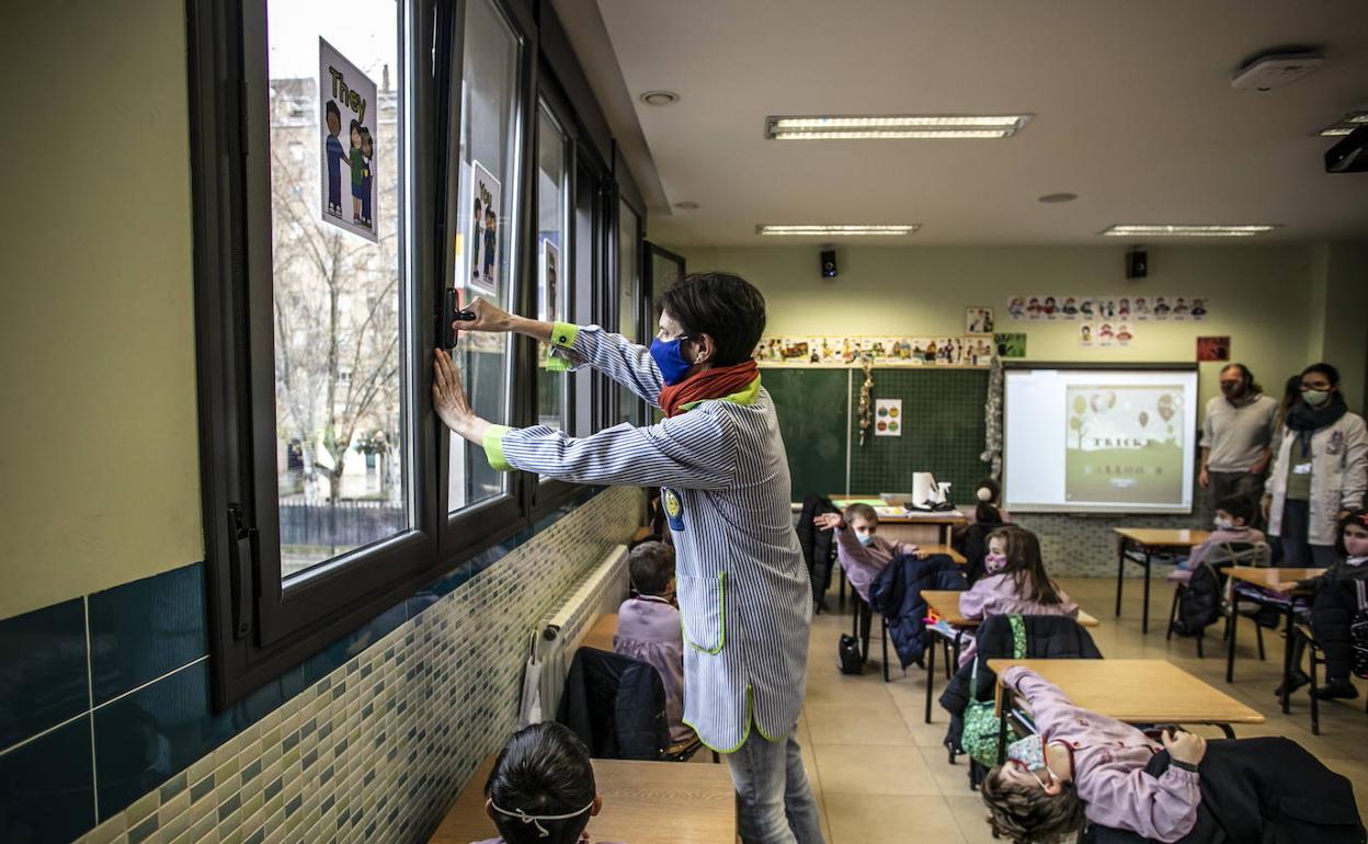 Una maestra procede a abrir la ventana para ventilar el aula y evitar la transmisión del coronavirus, en una imagen de archivo. 