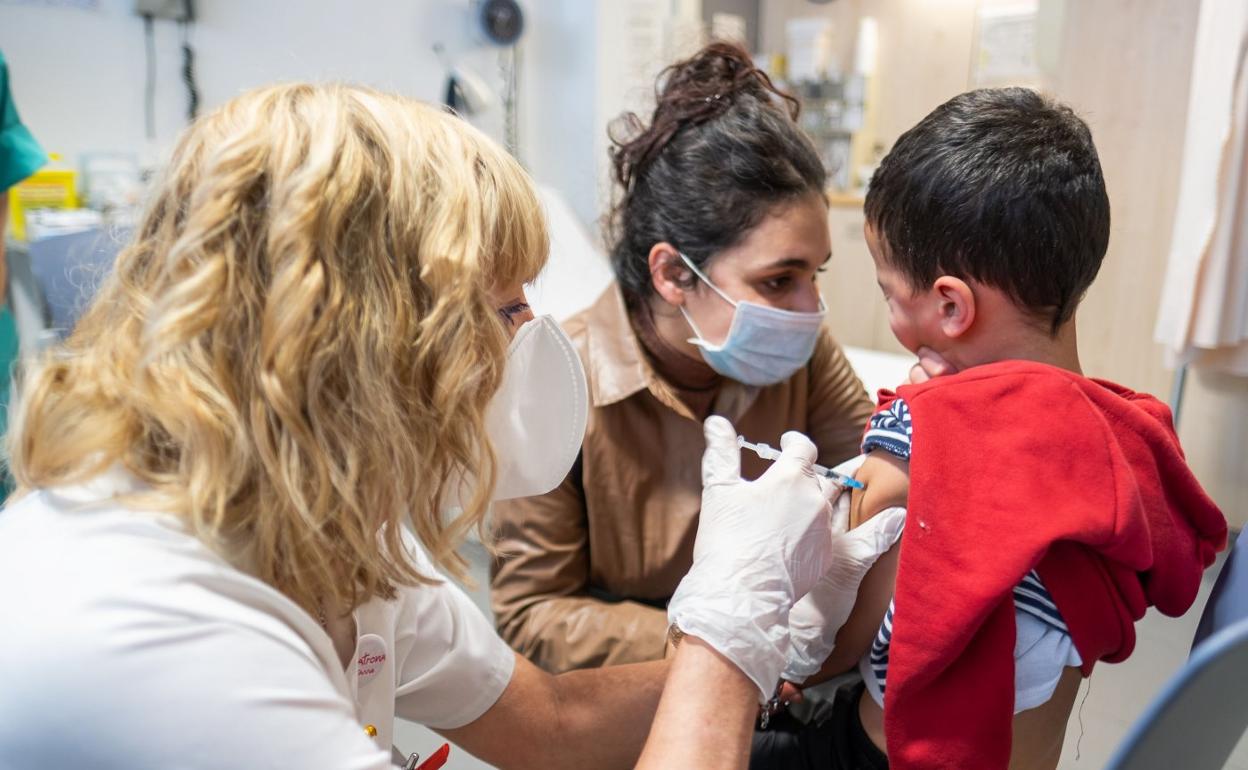 Un niño, acompañado por su madre, recibe la primera dosis de la vacuna frente al COVID en el centro de salud de Arnedo durante las pasadas vacaciones navideñas. 