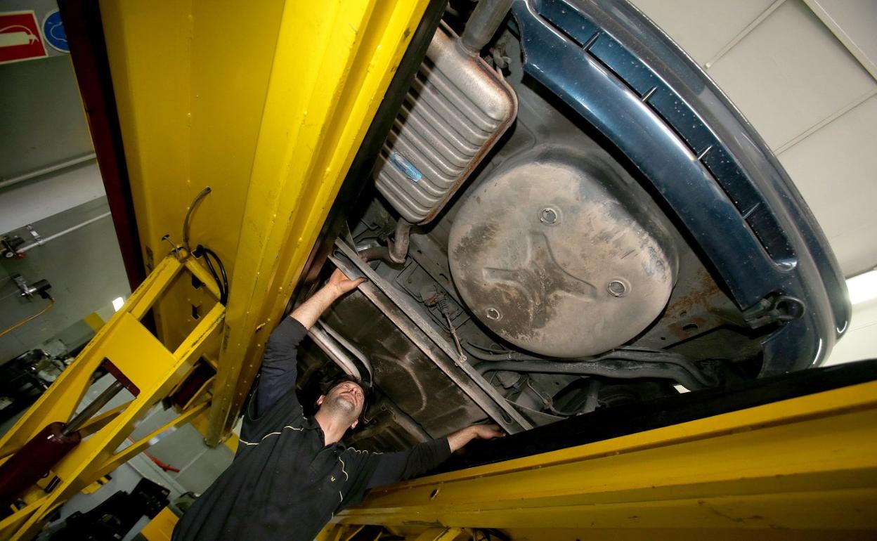 Un mecánico trabajando con un coche en un taller riojano de reparación de automóviles. 