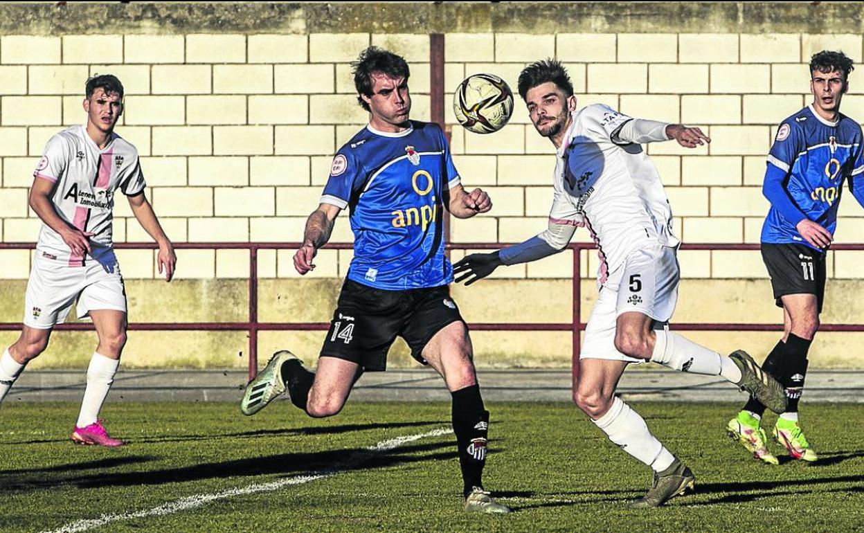 El racingista Marcos y un jugador del Peña Sport intentan hacerse con el esférico