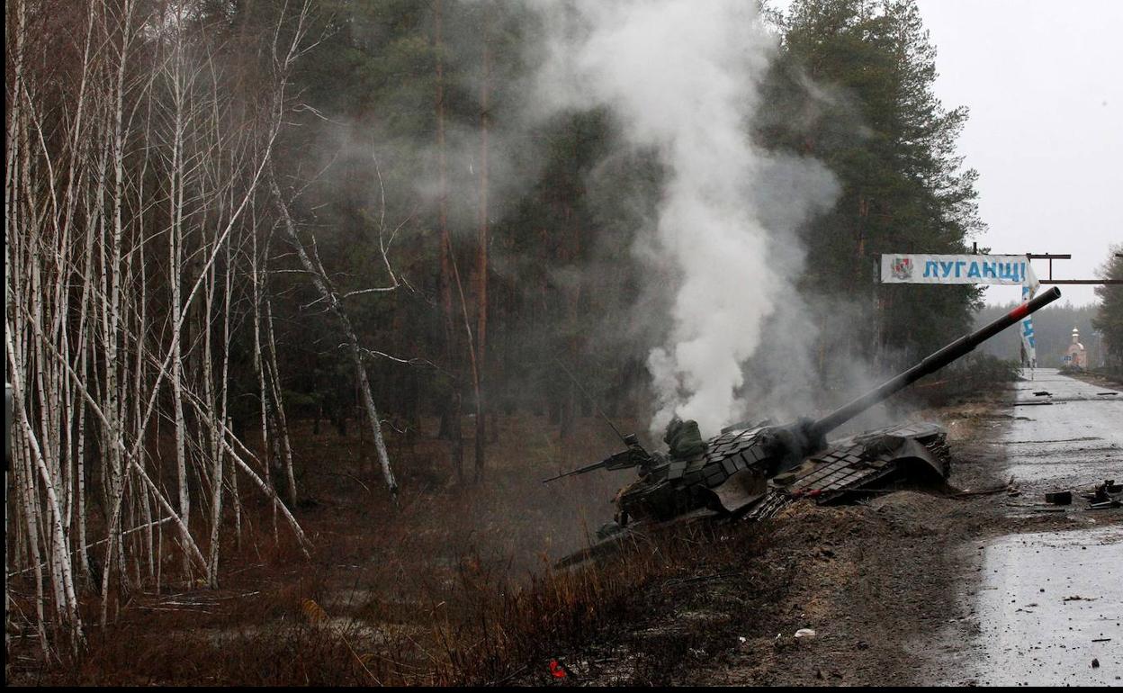 Un tanque ruso desprende humo tras ser destrozados por las tropas ucranianas en una carretera de Lugansk. 