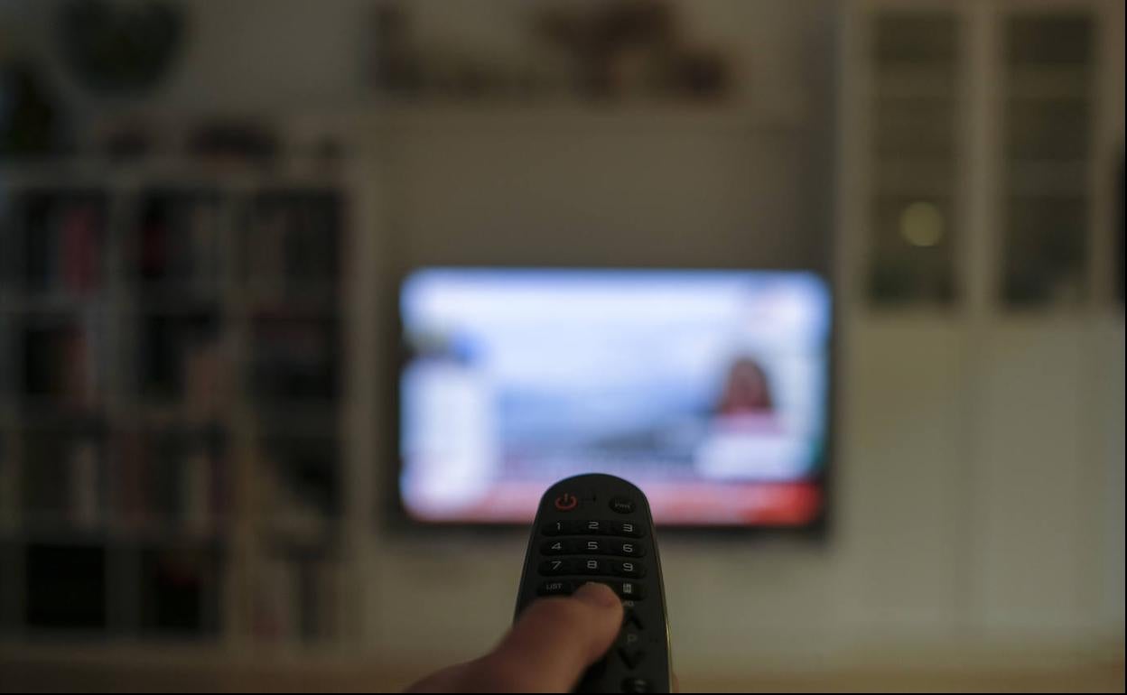 Un espectador usa el mando de su televisor.