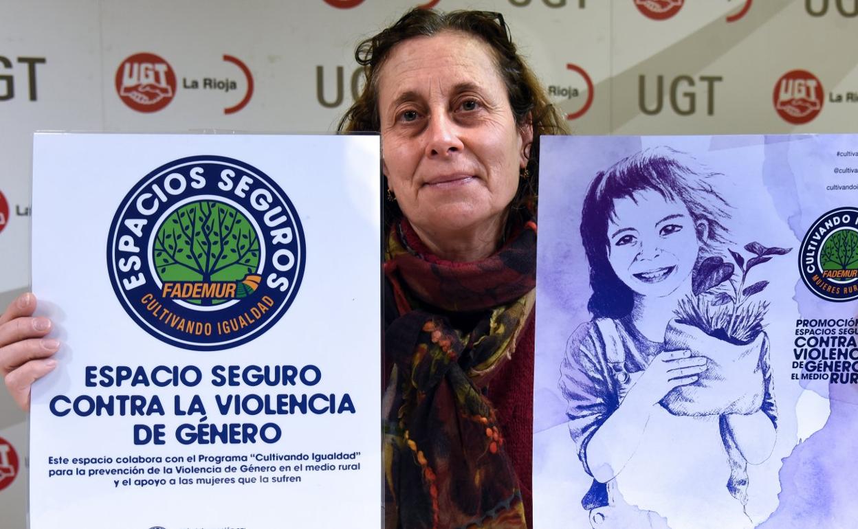 Mila Díez González sostiene unos carteles sobre los espacios seguros contra la violencia de género. 