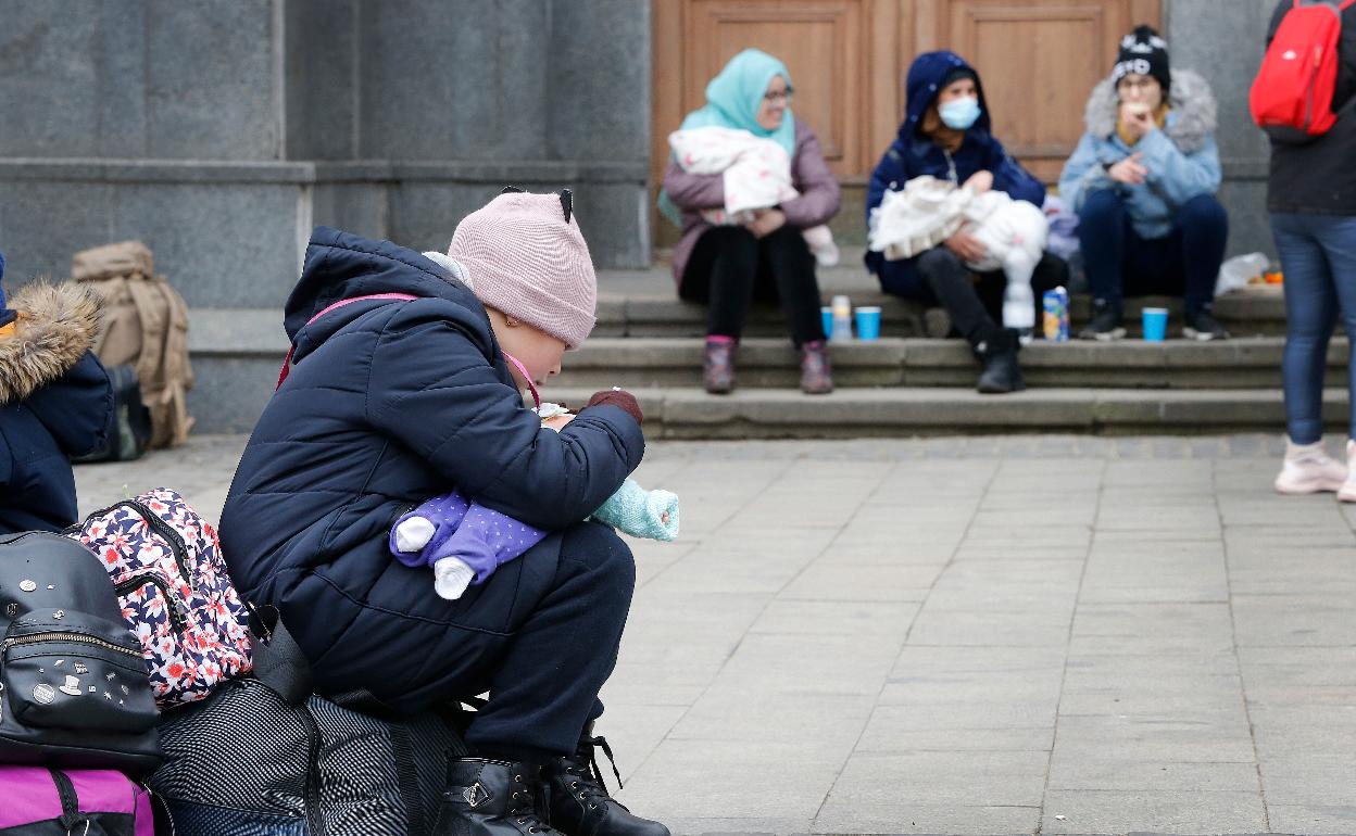 Niños y mujeres ucranianos, esperan cerca de la estación de Lviv para partir hacia Polonia. 