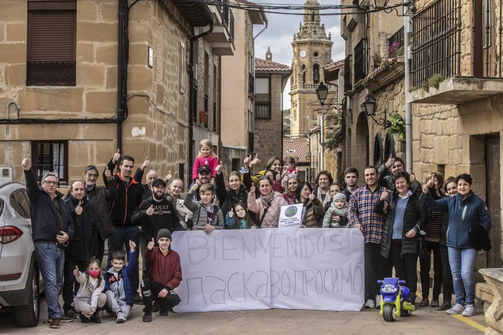 Vecinos de Ábalos, miembros de Fademur y los ucranianos acogidos en el pueblo posan con la torre de la iglesia de San Esteban Protomártir al fondo. 