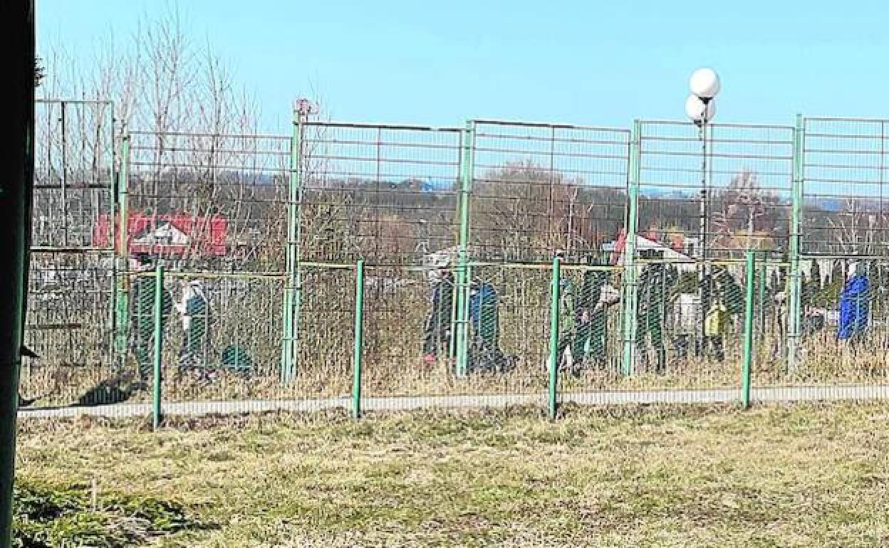 Decenas de refugiados ucranianos recorren a pie los últimos metros hasta la frontera para acceder a Polonia cargados con sus pertenencias, expulsados por los ataques del Ejército ruso en su país, este viernes, frente al área donde descarga el camión murciano.