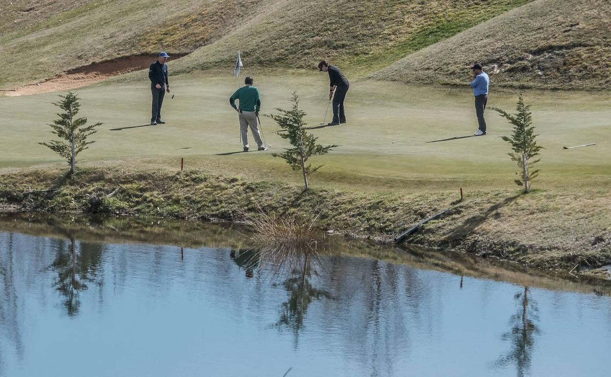 Los integrantes de un partido concluyen el hoyo junto al lago. 