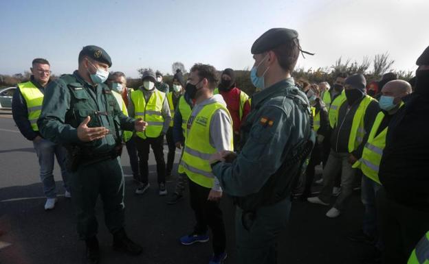 Dos agentes de la Guardia Civil hablan con los miembros de un piquete 