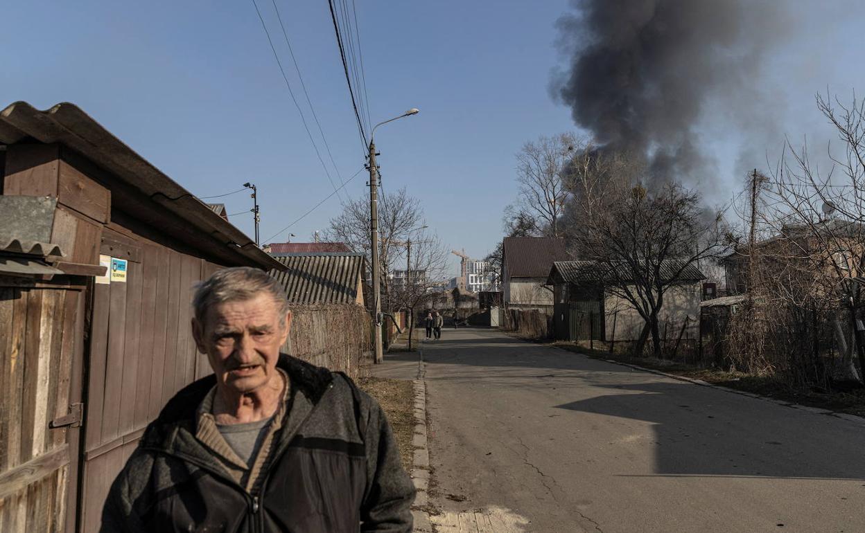 Un anciano camina por uno de los extrarradios de Kiev mientras se produce un bombardeo.