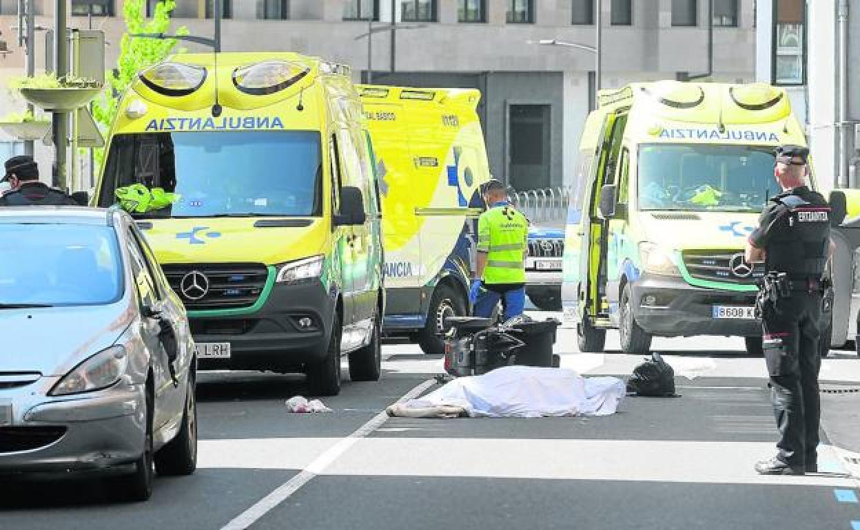 El cuerpo del fallecido cubierto por una sábana, junto a su silla de ruedas, frente al paso de peatones donde fue arrollado. 