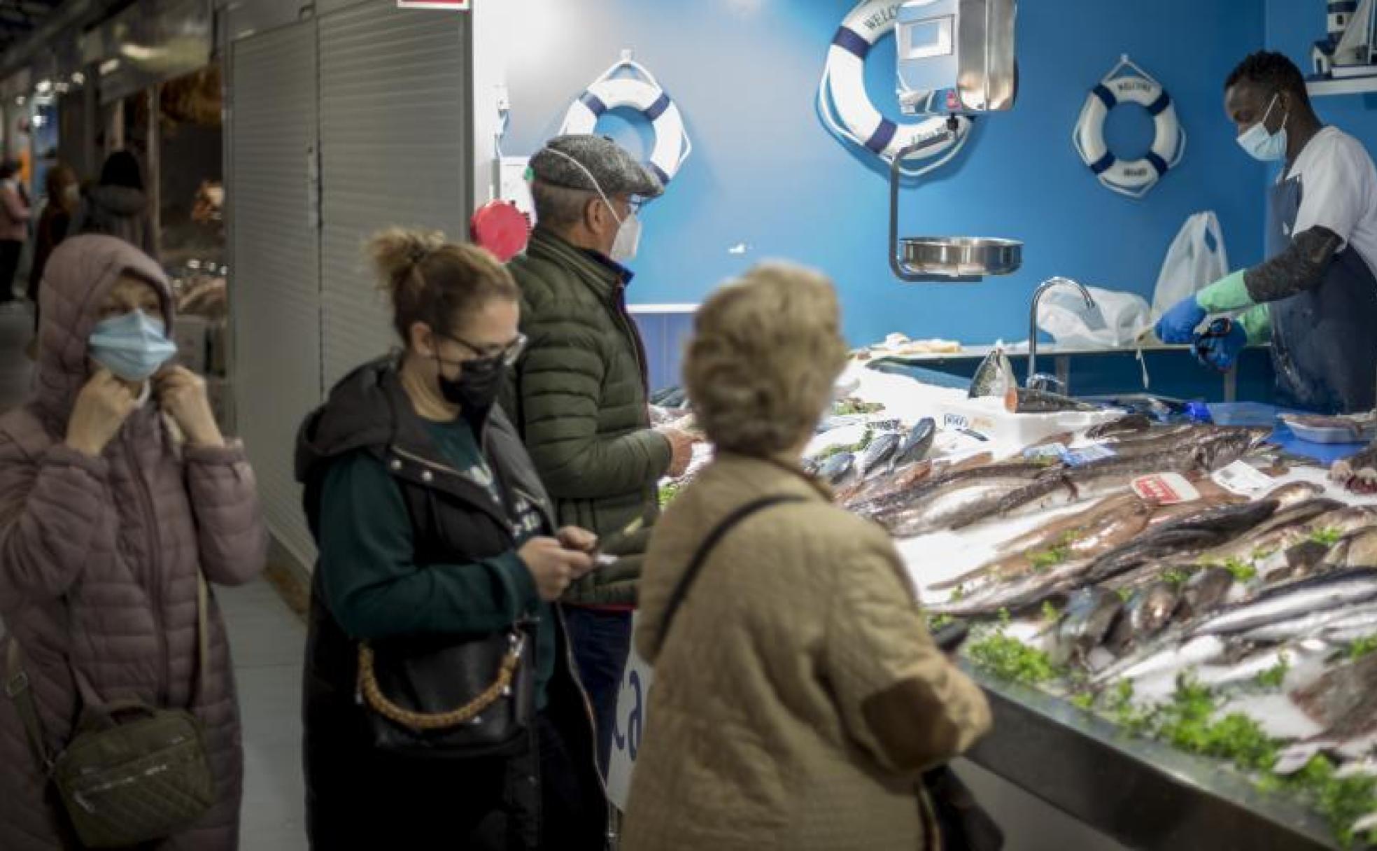 Clientes de un mercado de Ourense con la mascarilla. 