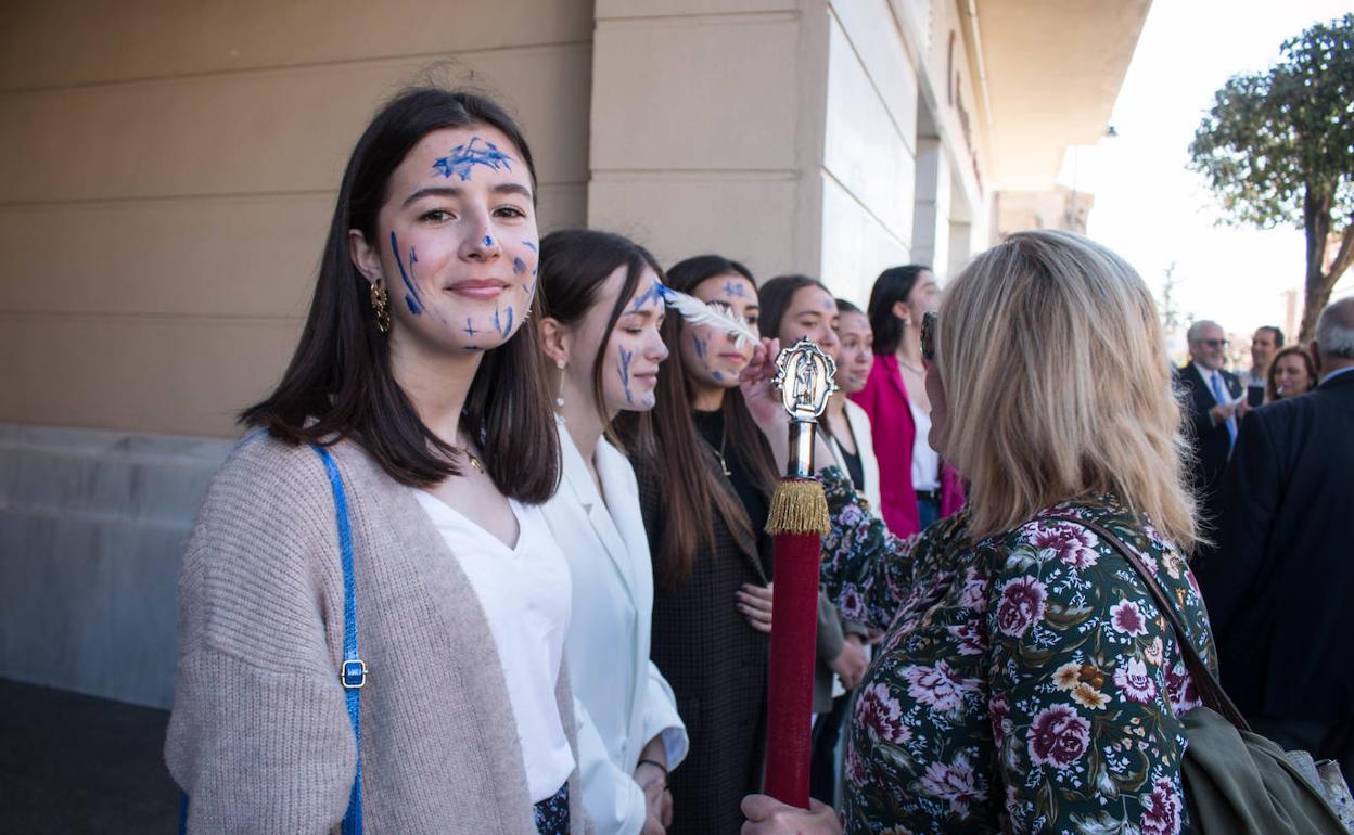 Una de las cofrades, Mari Cruz Uruñuela, pinta a unas jóvenes. Lo hacen cofrades y munícipes, después de los priores. 