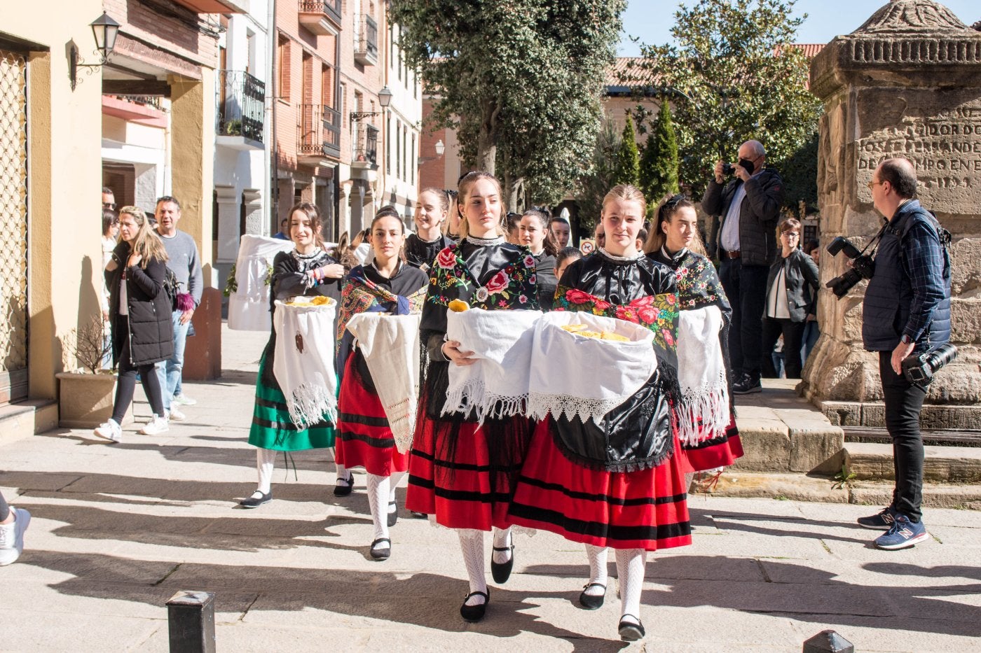 Un grupo de doncellas, con cestaños y ataviadas con trajes regionales, en los primeros momentos del reparto del pan del Santo. 