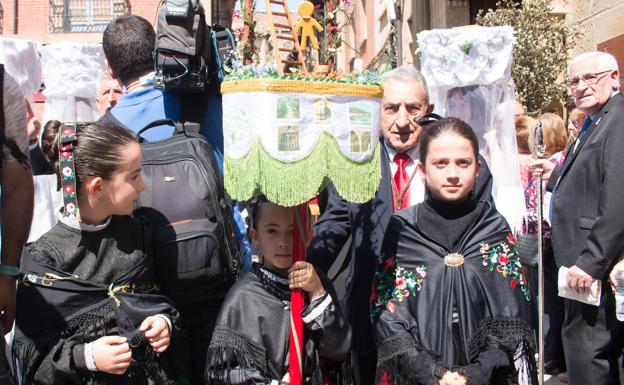 Unas niñas acompañan el estandarte hecho por Javier Luzuriaga. 