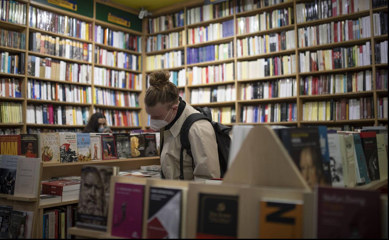 Un lector, hojeando un libro en una libreria.