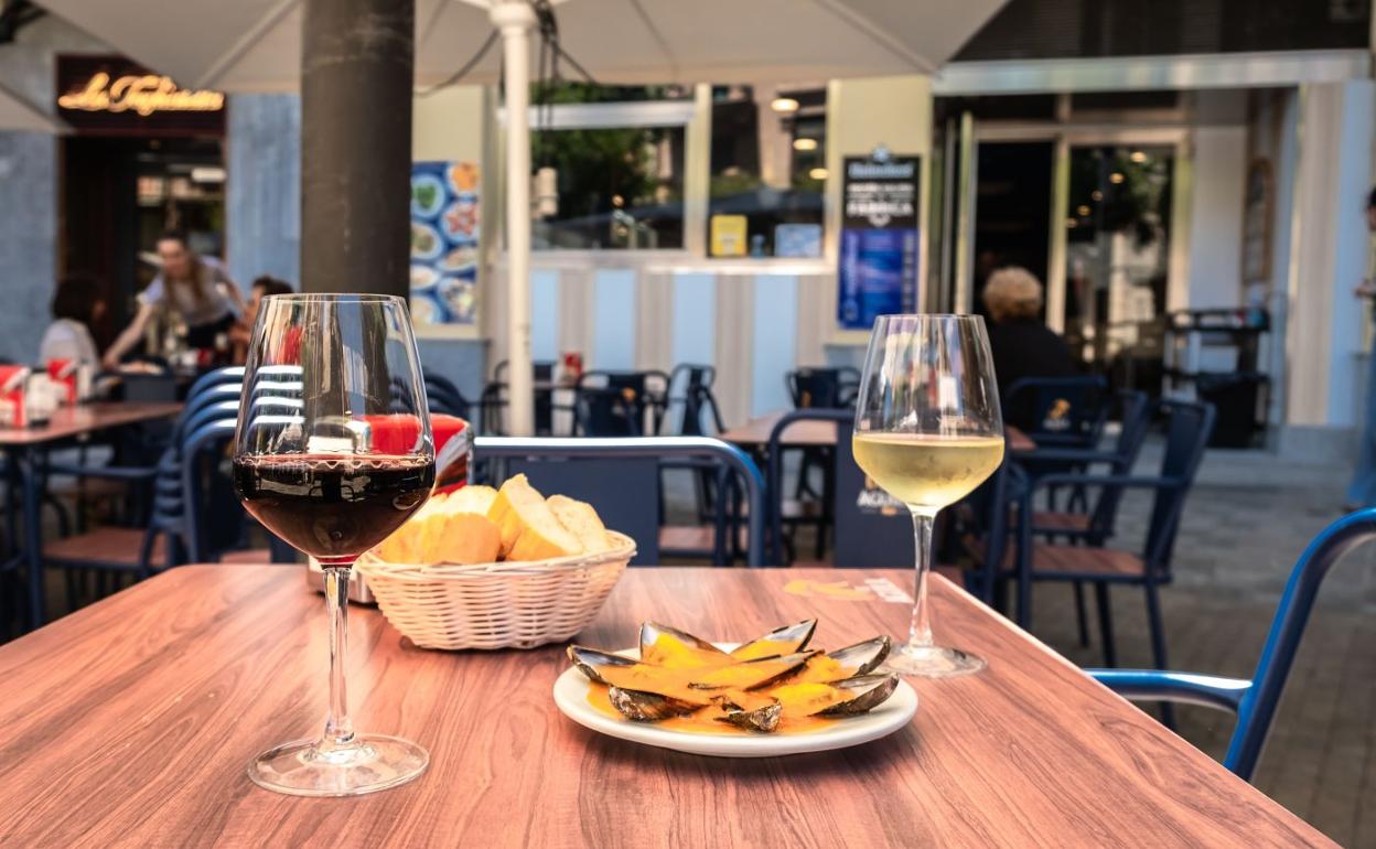 Una de las mesas de la terraza de La Mejillonera con dos vinos y un plato de sus icónicos mejillones. 