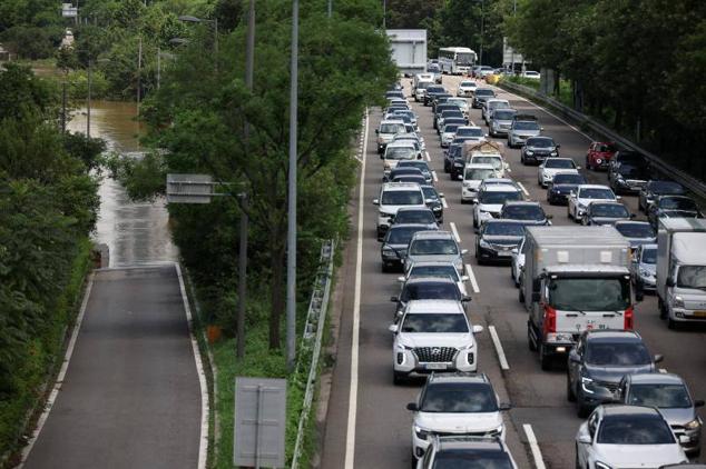 Cientos de personas han tenido que ser evacuadas. En la imagen, una carretera colapsada por vecinos que huyen de la crecida del río Han, en Seúl.