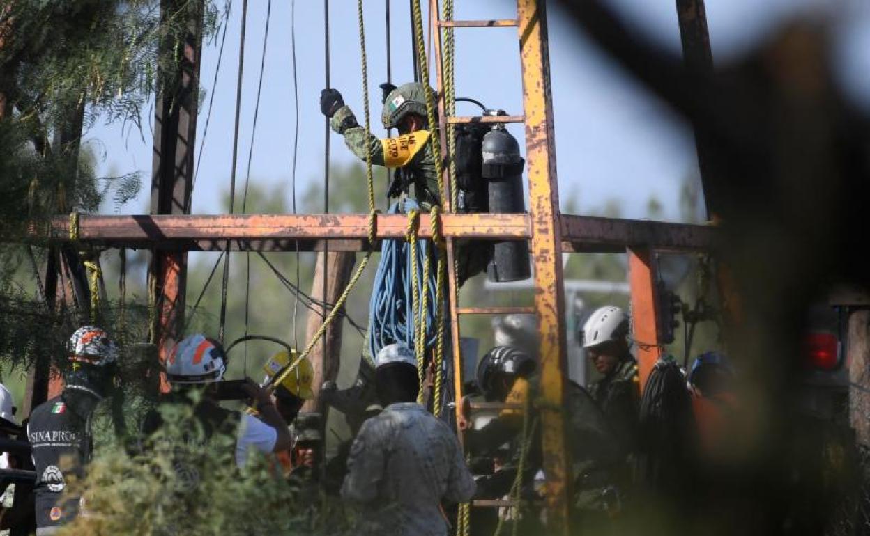 Un miembro del equipo de rescate a punto de entrar en la jaula para descender al pozo