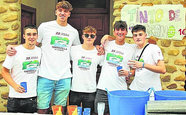 Unos jóvenz ofrecen tinto de verano en la Fiesta de la Solidaridad. 