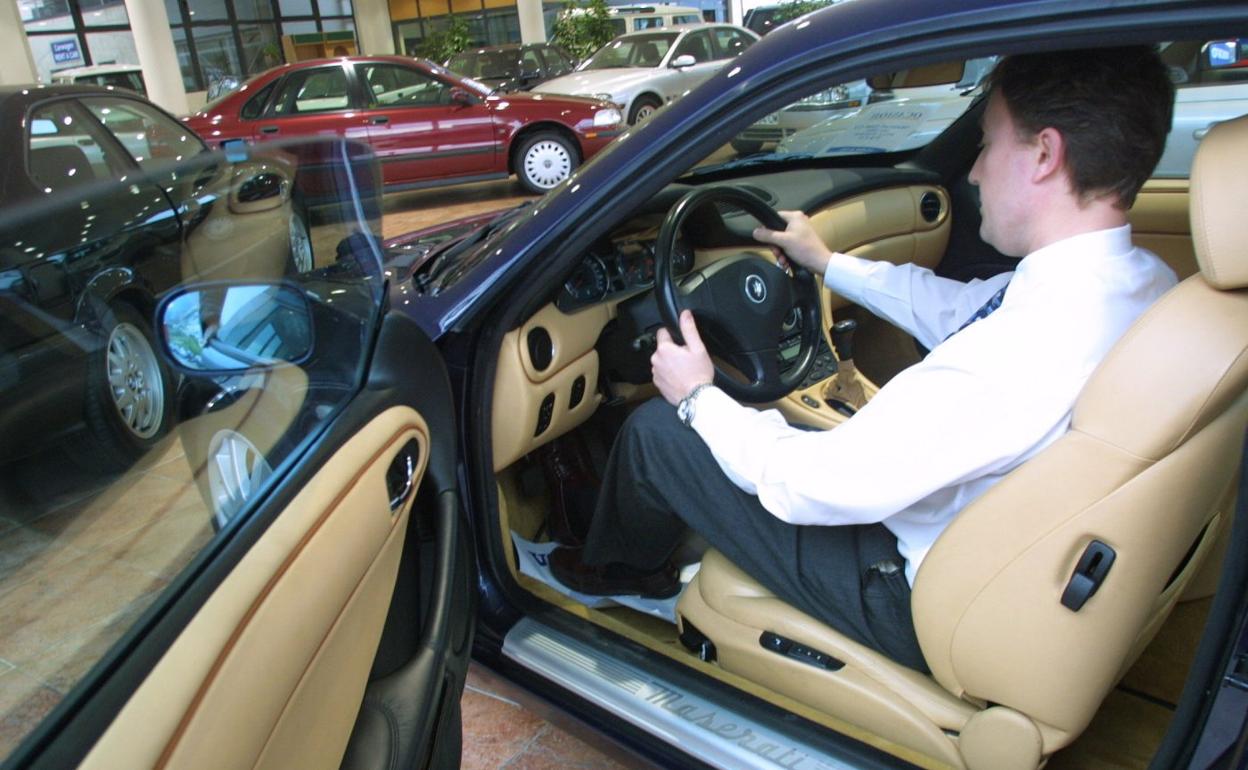 Un hombre prueba un coche en un concesionario, en una imagen de archivo. 